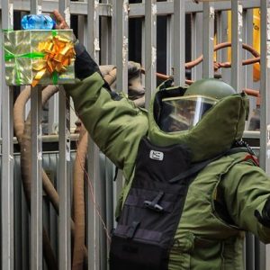 A police bomb specialist resisting a bomb from exploding